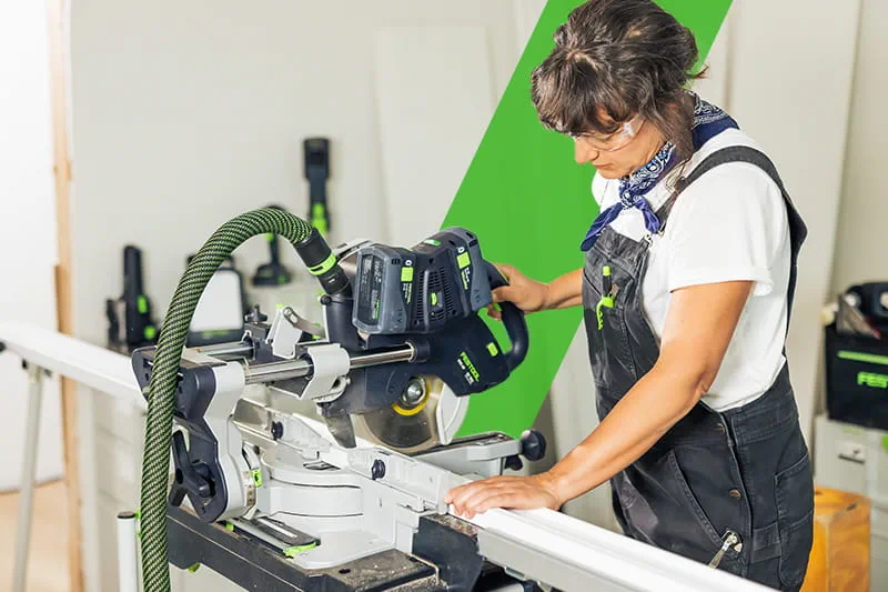 Woodworker cutting trim with KSC 60 miter saw