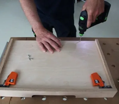 Pushing in and securing the bottom of the drawer