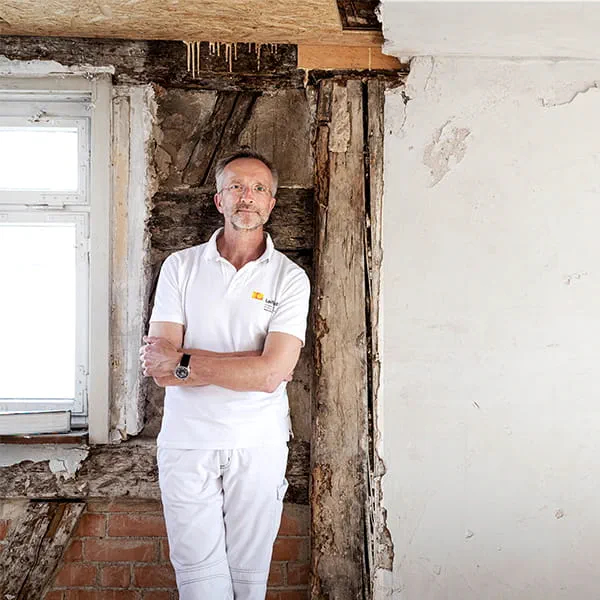 Manfred Schuler, master painter and restorer, in front of the wall in the timber frame house to be restored