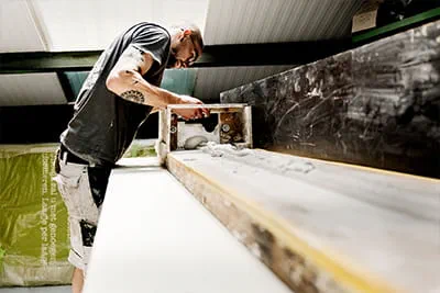 Using simple tools and traditional methods, Sam is working on a stucco moulding upstairs in the workshop.